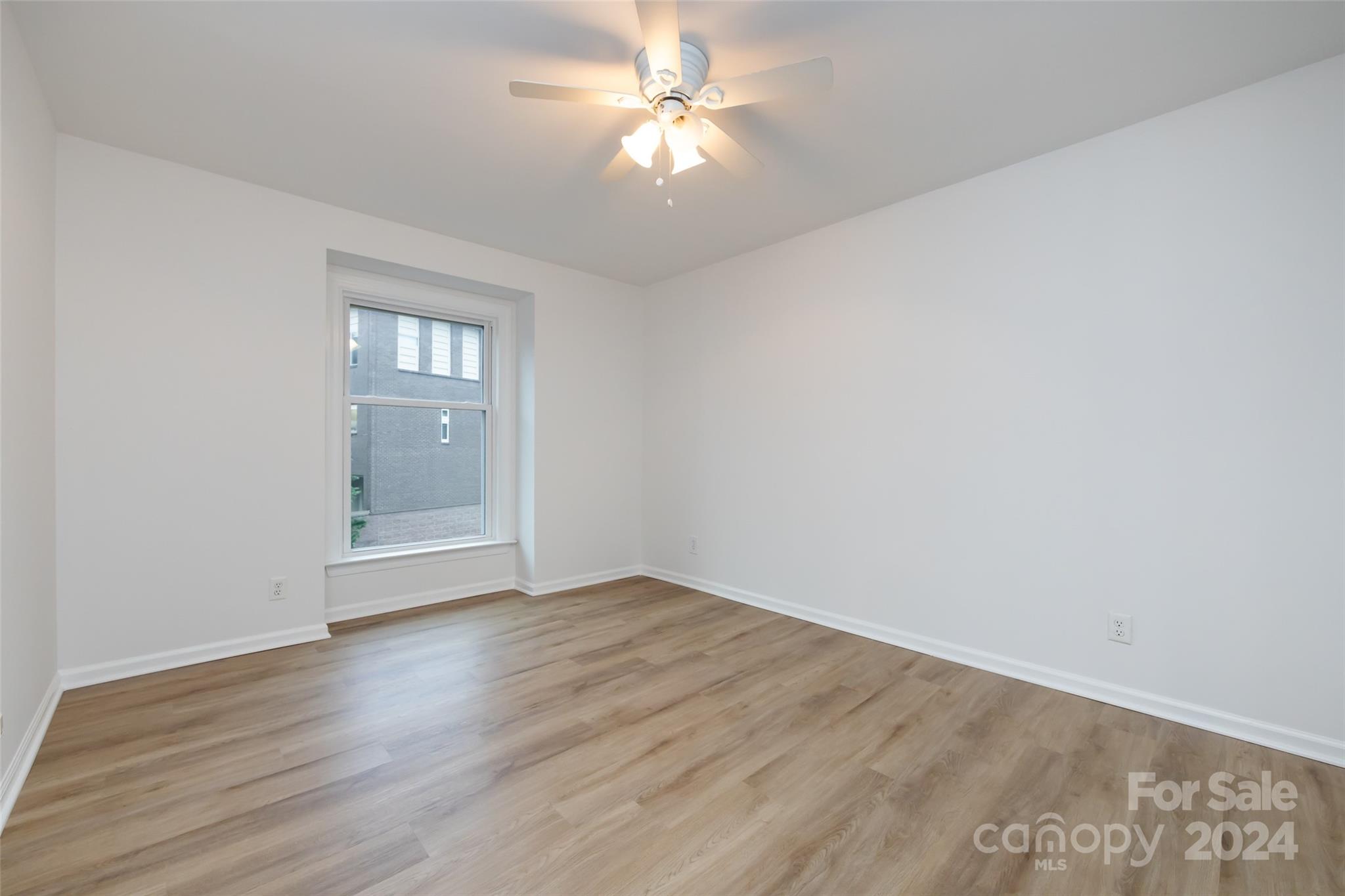 430 Queens Road, Unit 231 Charlotte, NC 28207 - Photo 19 of 23 wooden floor in an empty room with a window