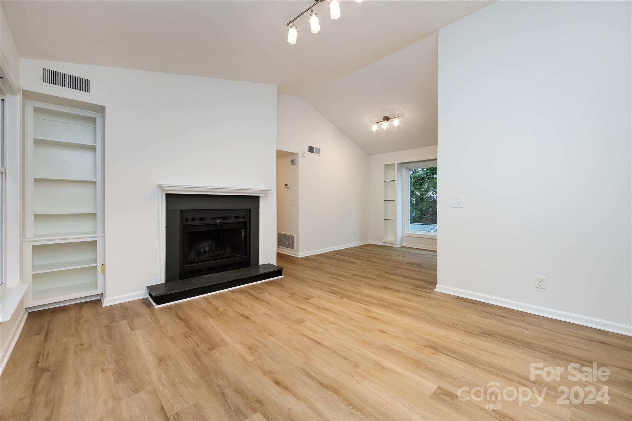430 Queens Road, Unit 231 Charlotte, NC 28207 - Photo 6 of 23 a view of an empty room with a fireplace and cabinet