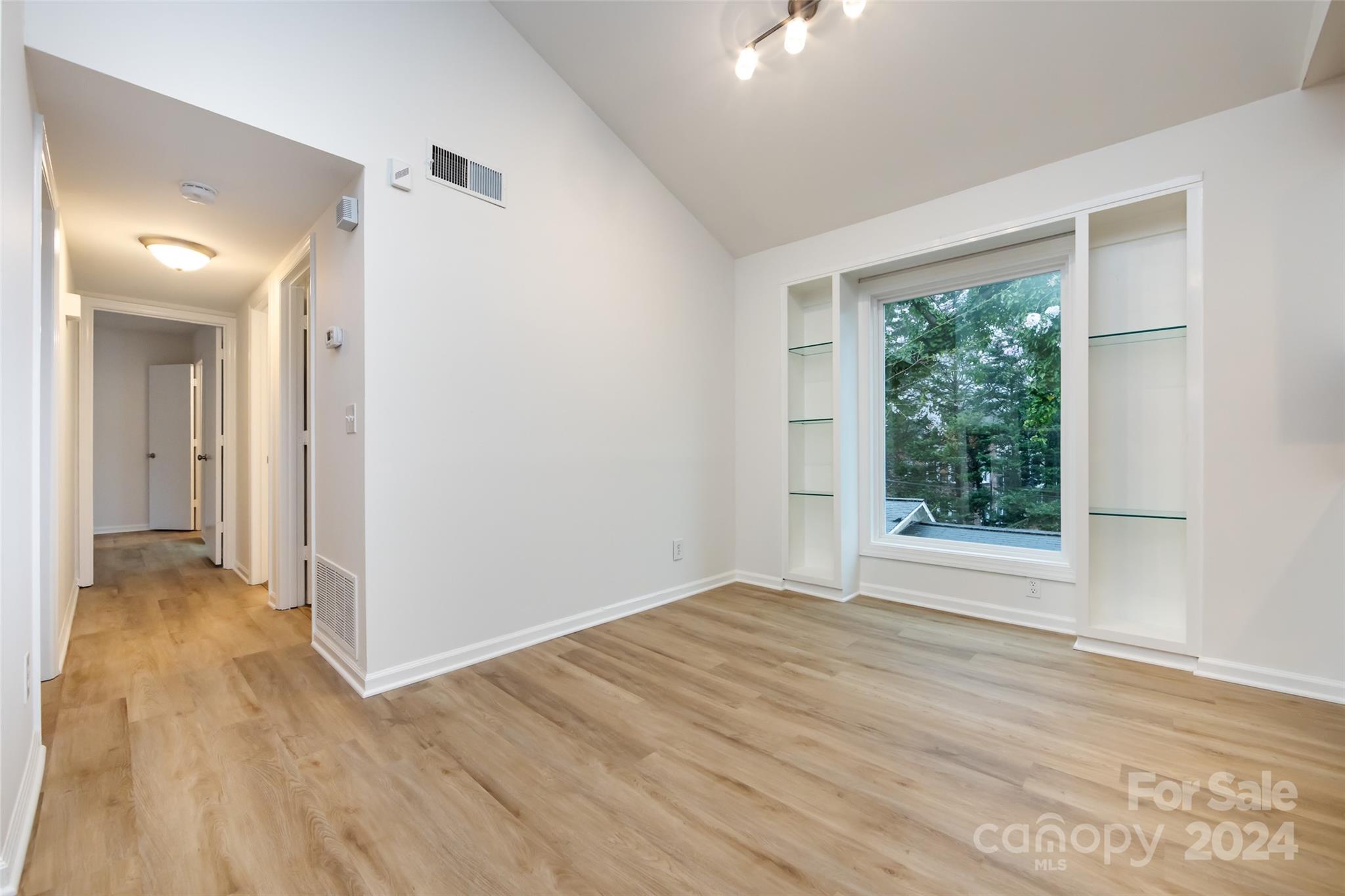 430 Queens Road, Unit 231 Charlotte, NC 28207 - Photo 8 of 23 an empty room with wooden floor and windows