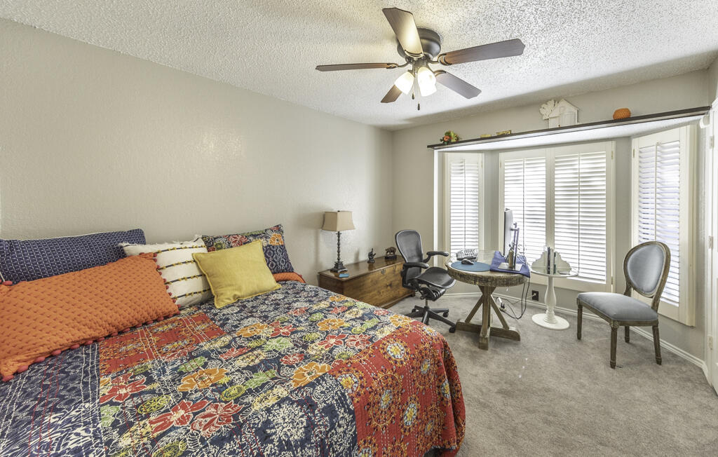 3620 93rd Street Lubbock, TX 79423 - Photo 21 of 33 a bedroom with a bed and a chandelier