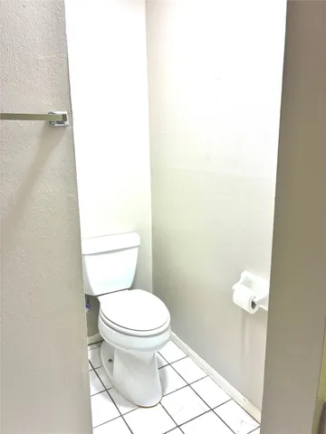 a white toilet sitting next to a white wall