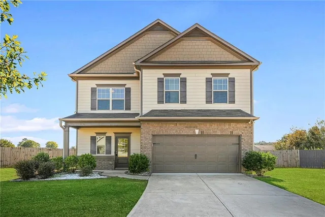 a front view of a house with a yard and garage