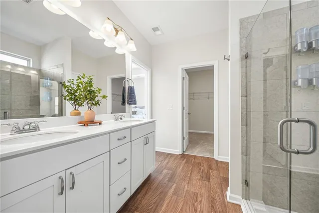 a bathroom with a double vanity sink mirror and shower