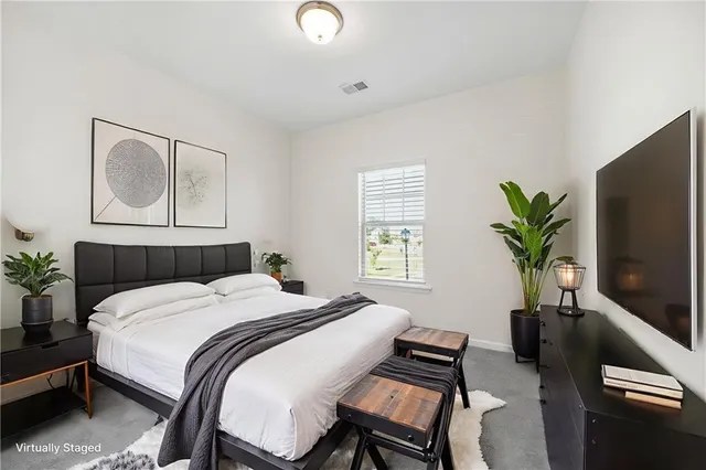 a bedroom with a bed a couch and a potted plant