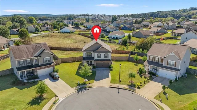 an aerial view of a house with swimming pool and a garden