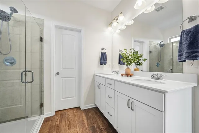 a bathroom with a double vanity sink mirror and shower