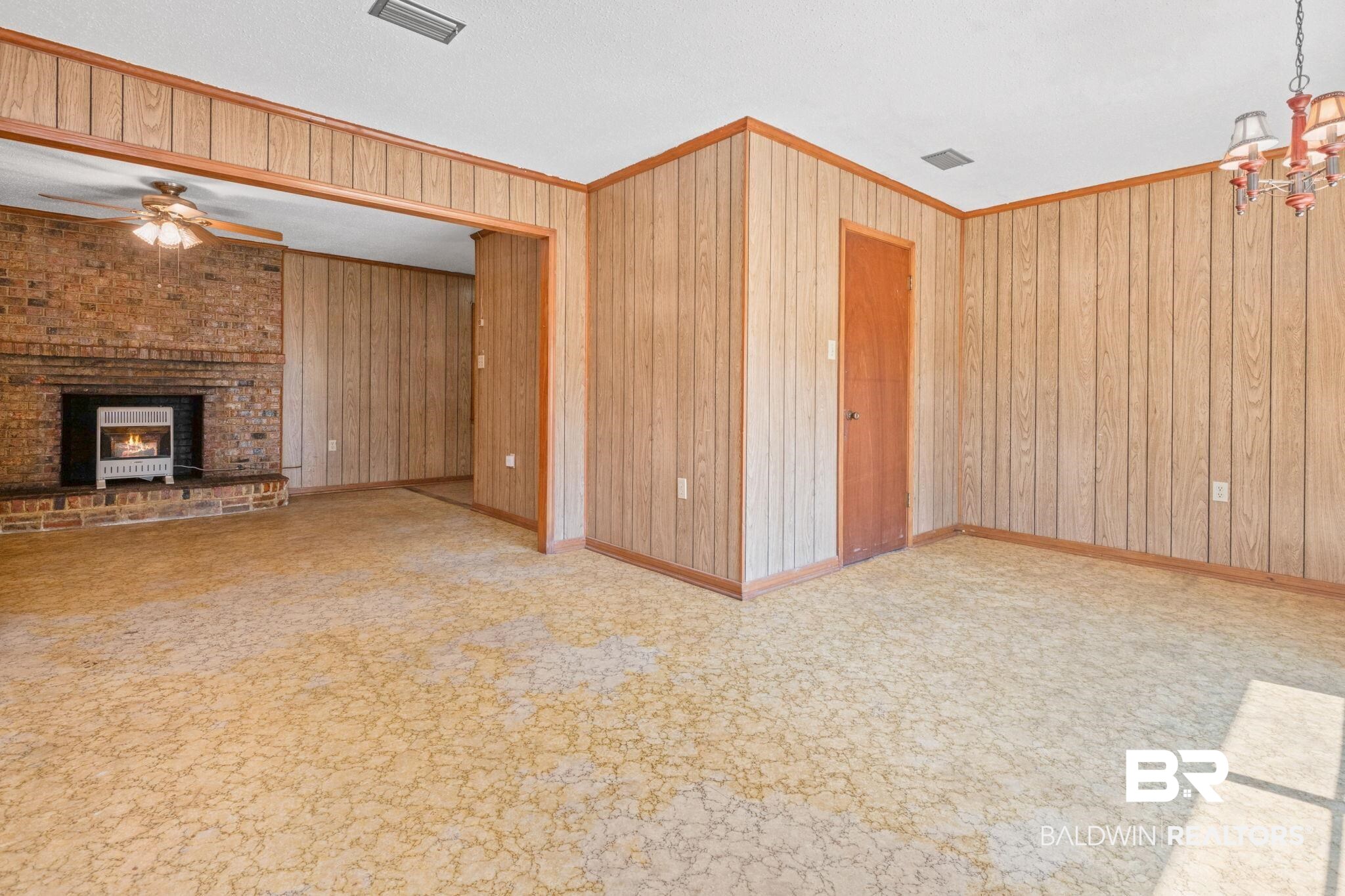 1456 Herman Williams Road Fruitdale, AL 36539 - Photo 8 of 24 Unfurnished living room featuring ornamental molding, light colored carpet, ceiling fan with notable chandelier, and wood walls