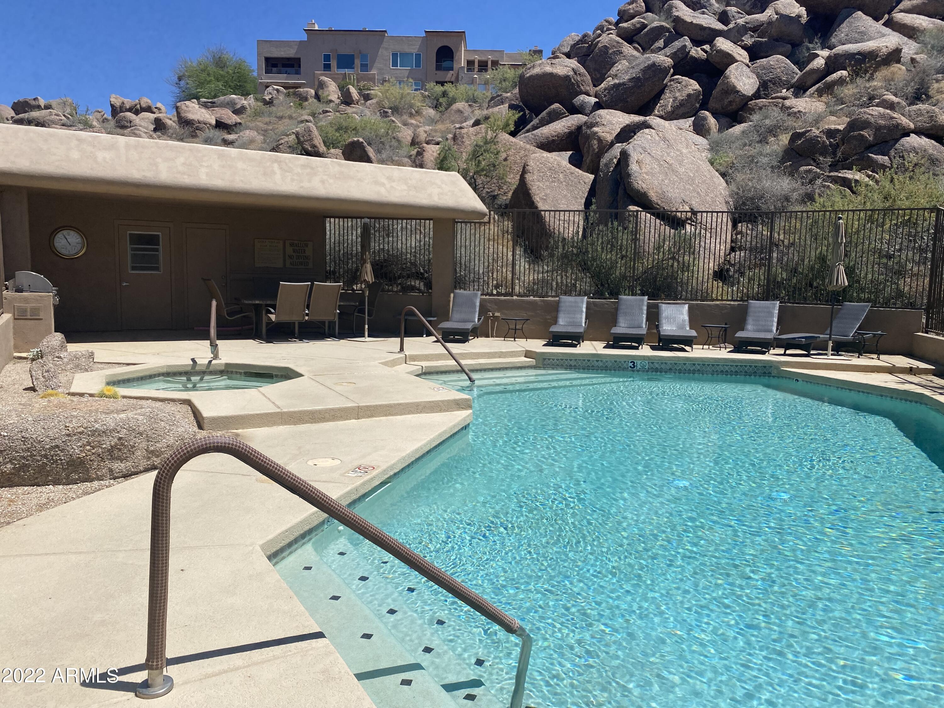 10222 East Southwind Lane, Unit 1009 Scottsdale, AZ 85262 - Photo 38 of 44 a view of a patio with table and chairs under an umbrella