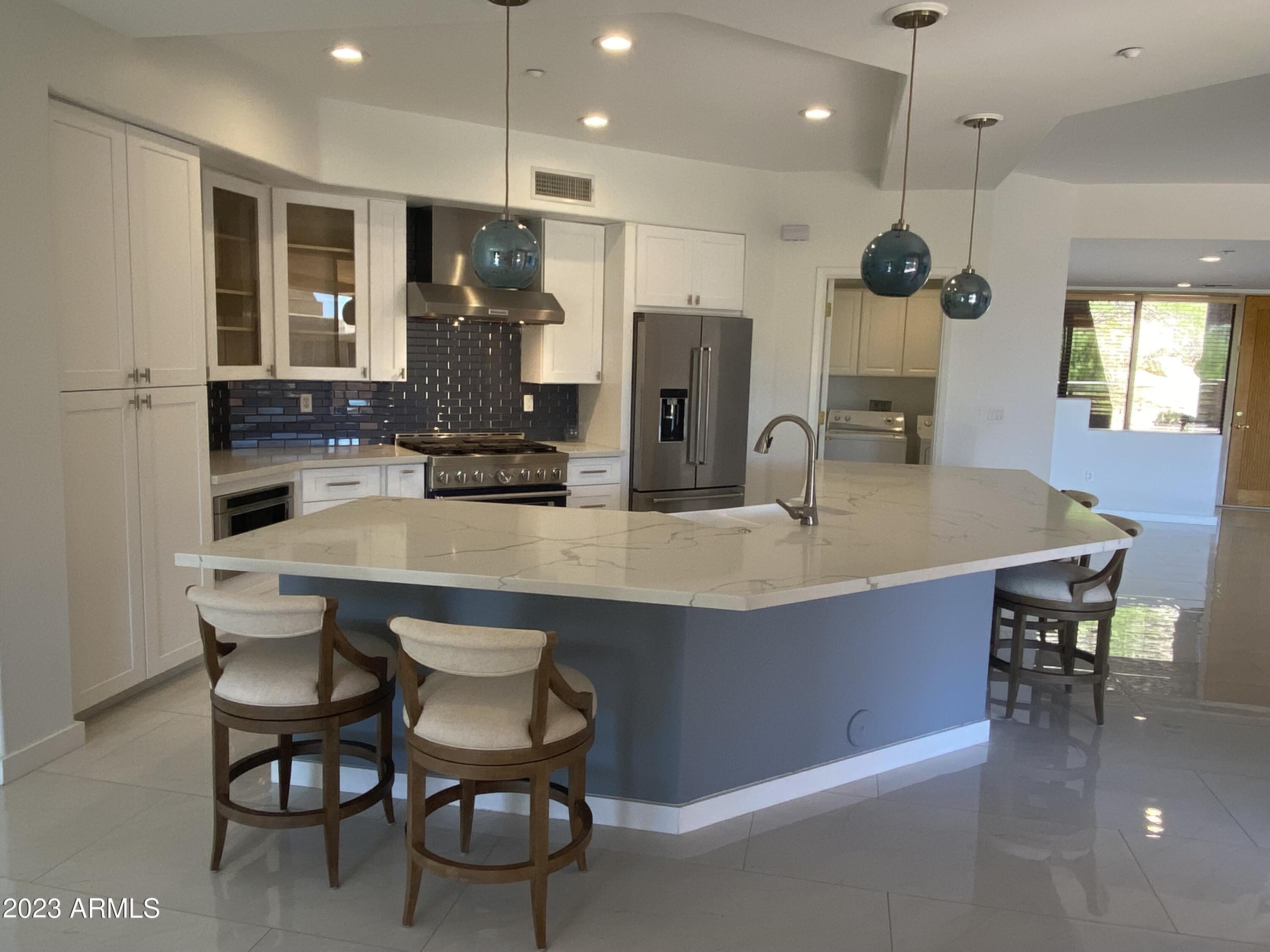 10222 East Southwind Lane, Unit 1009 Scottsdale, AZ 85262 - Photo 8 of 44 a kitchen with stainless steel appliances granite countertop a kitchen island a stove and a sink