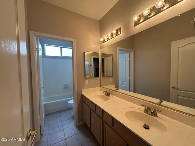 a spacious bathroom with a double vanity sink and a mirror