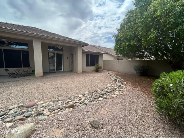 a view of a house with a yard and potted plants