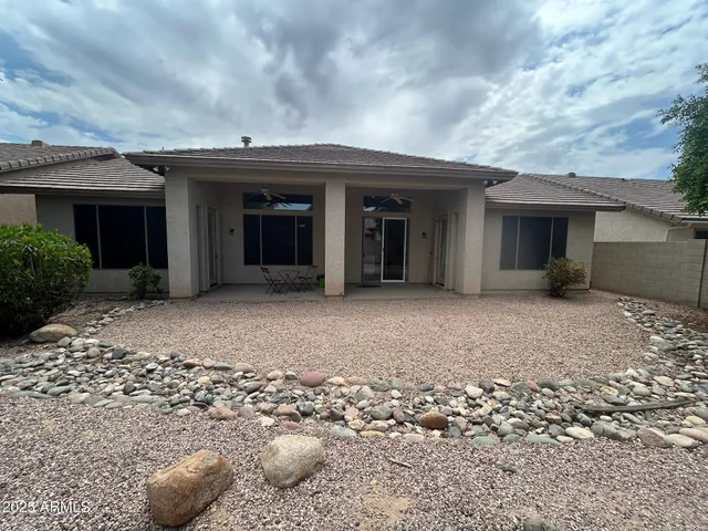 a view of a house with a backyard and potted plants