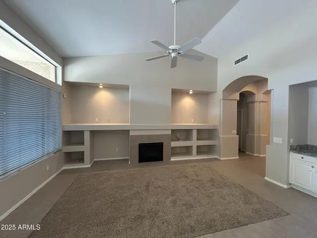 an empty room with a fireplace and cabinet