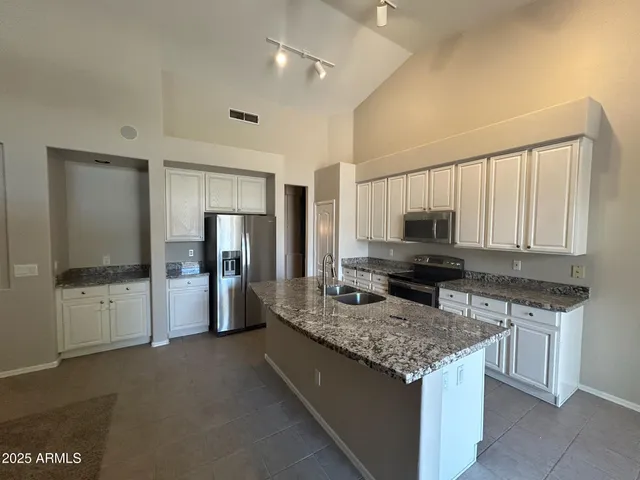 a large kitchen with a stove a refrigerator and a sink