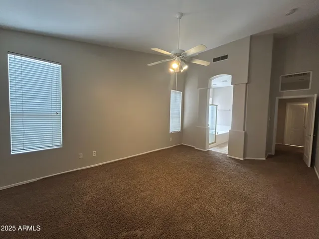 an empty room with windows and fan