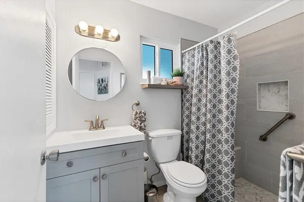 a bathroom with a toilet a sink and a mirror