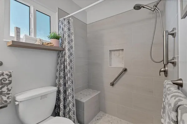 a bathroom with a shower a toilet and a sink