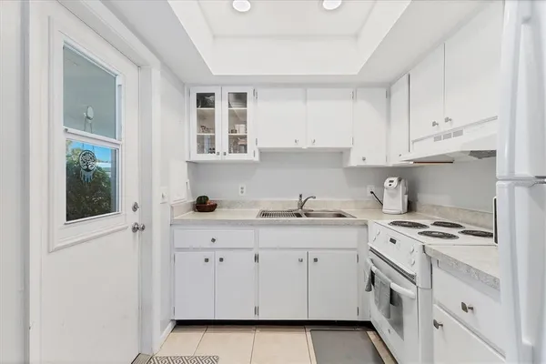 a kitchen with granite countertop a sink a stove and cabinets