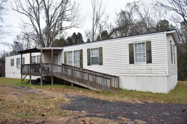 a backyard of a house with wooden deck and barbeque oven