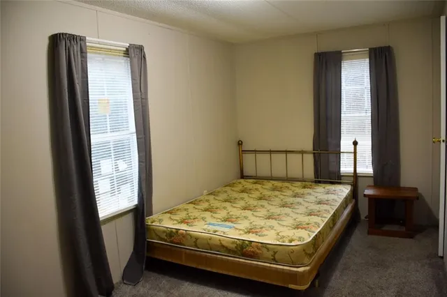 a bed sitting in a bedroom next to a window