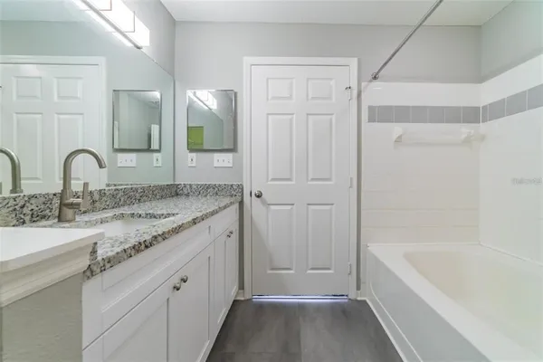 a bathroom with a granite countertop sink and a mirror