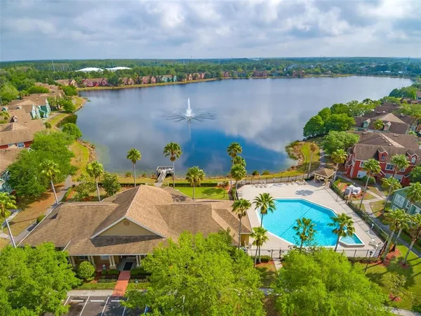 a view of a swimming pool with a lawn chairs under an umbrella