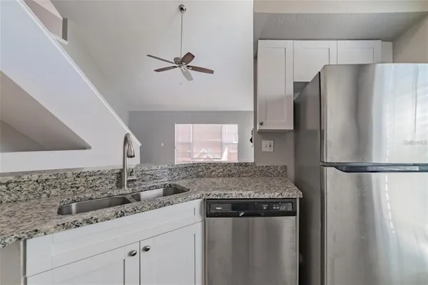 a kitchen with stainless steel appliances granite countertop a refrigerator and a sink