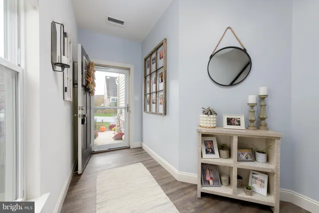 a kitchen with stainless steel appliances granite countertop a dining table chairs refrigerator and sink