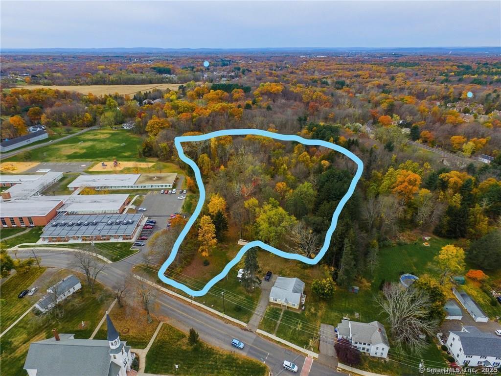 an aerial view of a residential houses with outdoor space and ocean view