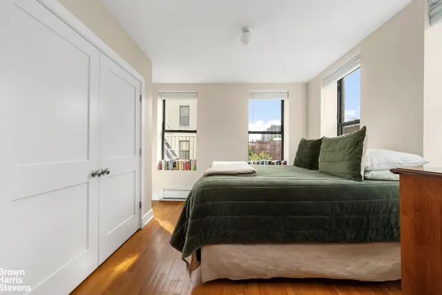a bed sitting in a bedroom next to a window