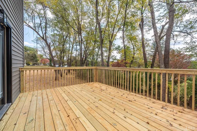 a balcony with wooden floor and trees
