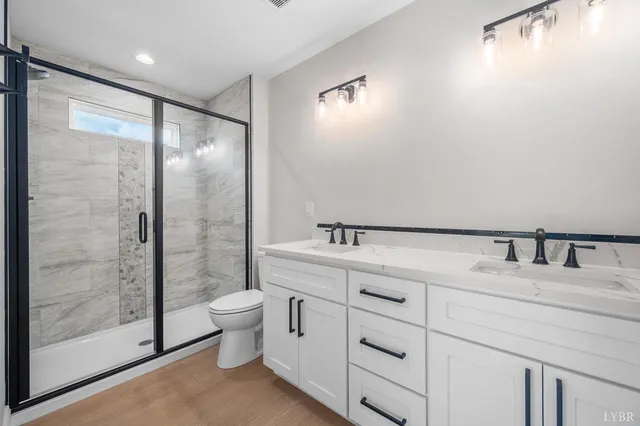 a bathroom with a granite countertop sink mirror and toilet