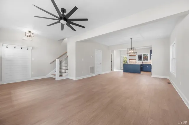a view of empty room with wooden floor and ceiling fan