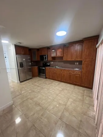 a large kitchen with cabinets and a stove top oven