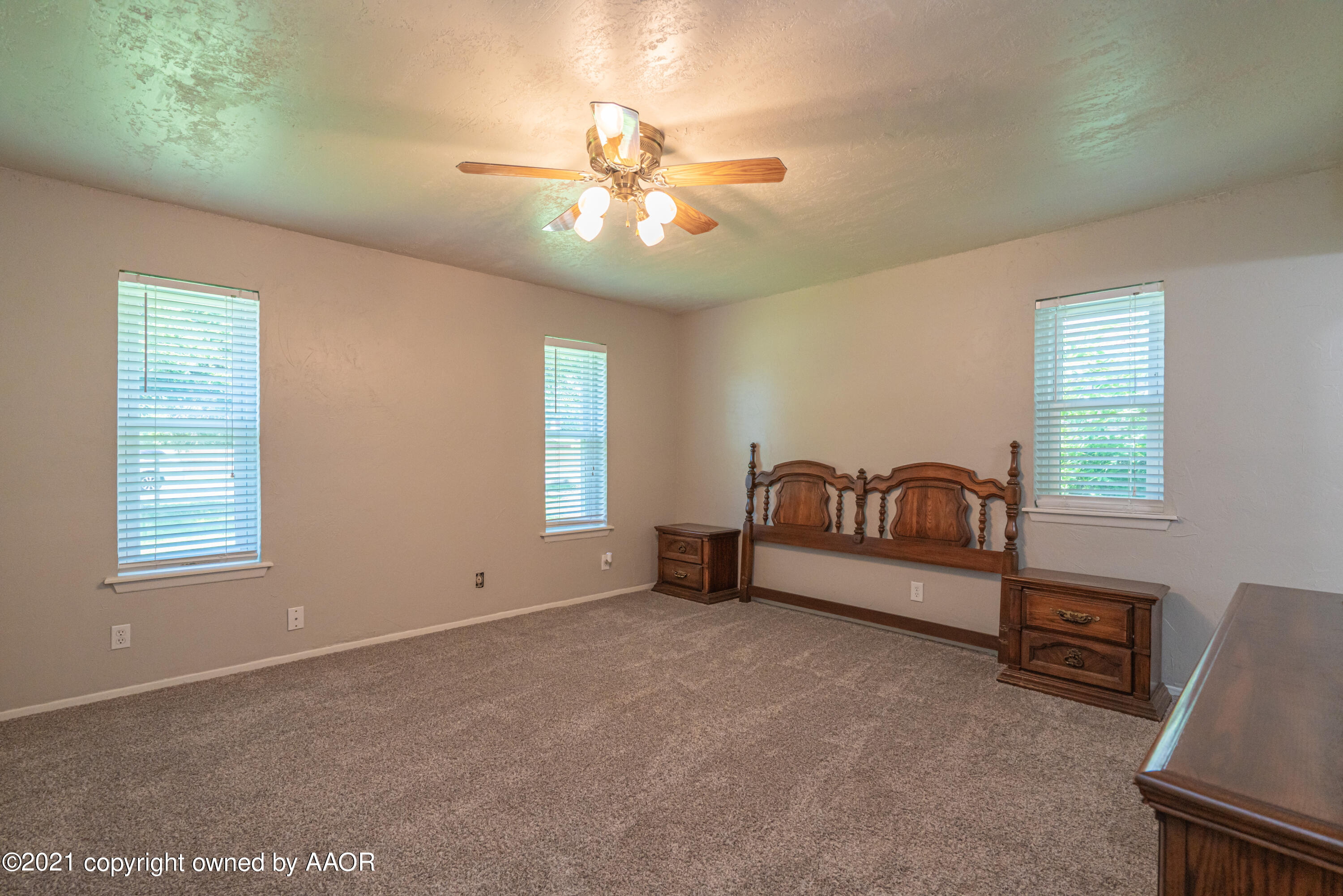 5308 Hillside Road Amarillo, TX 79109 - Photo 11 of 23 a spacious bedroom with a bed and a chandelier
