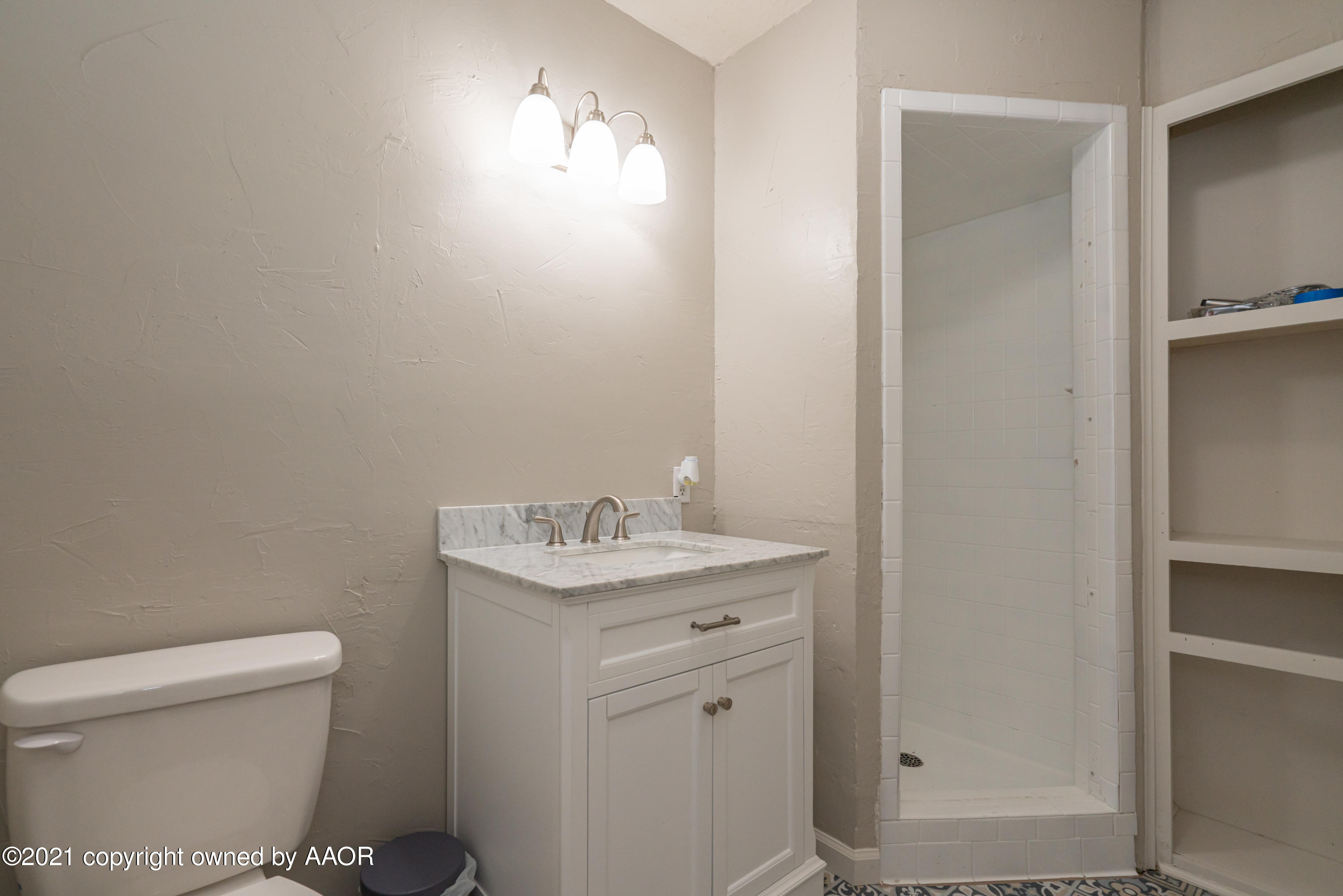 5308 Hillside Road Amarillo, TX 79109 - Photo 13 of 23 a bathroom with a toilet a sink and mirror