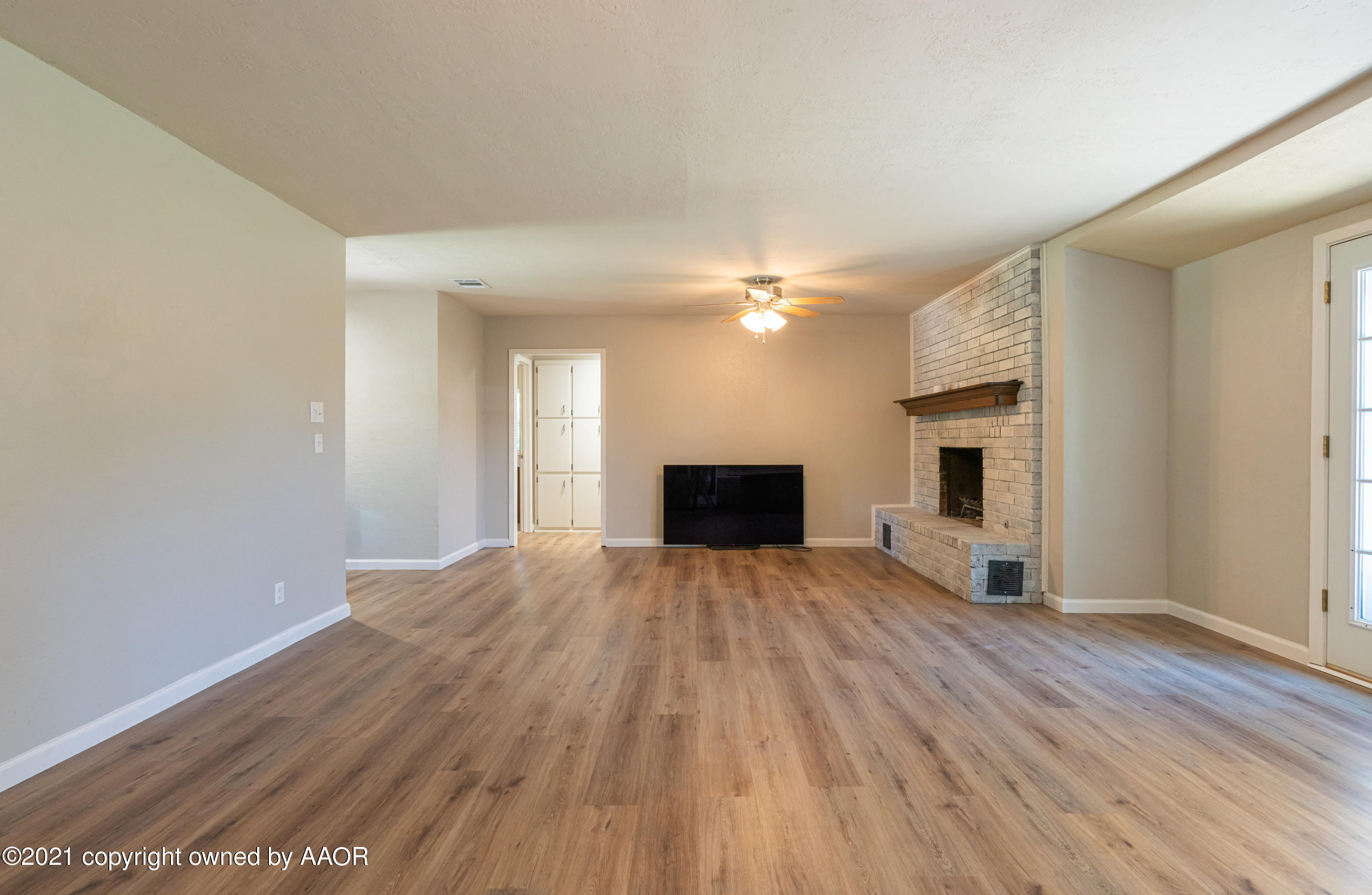5308 Hillside Road Amarillo, TX 79109 - Photo 4 of 23 a view of empty room with wooden floor and fireplace