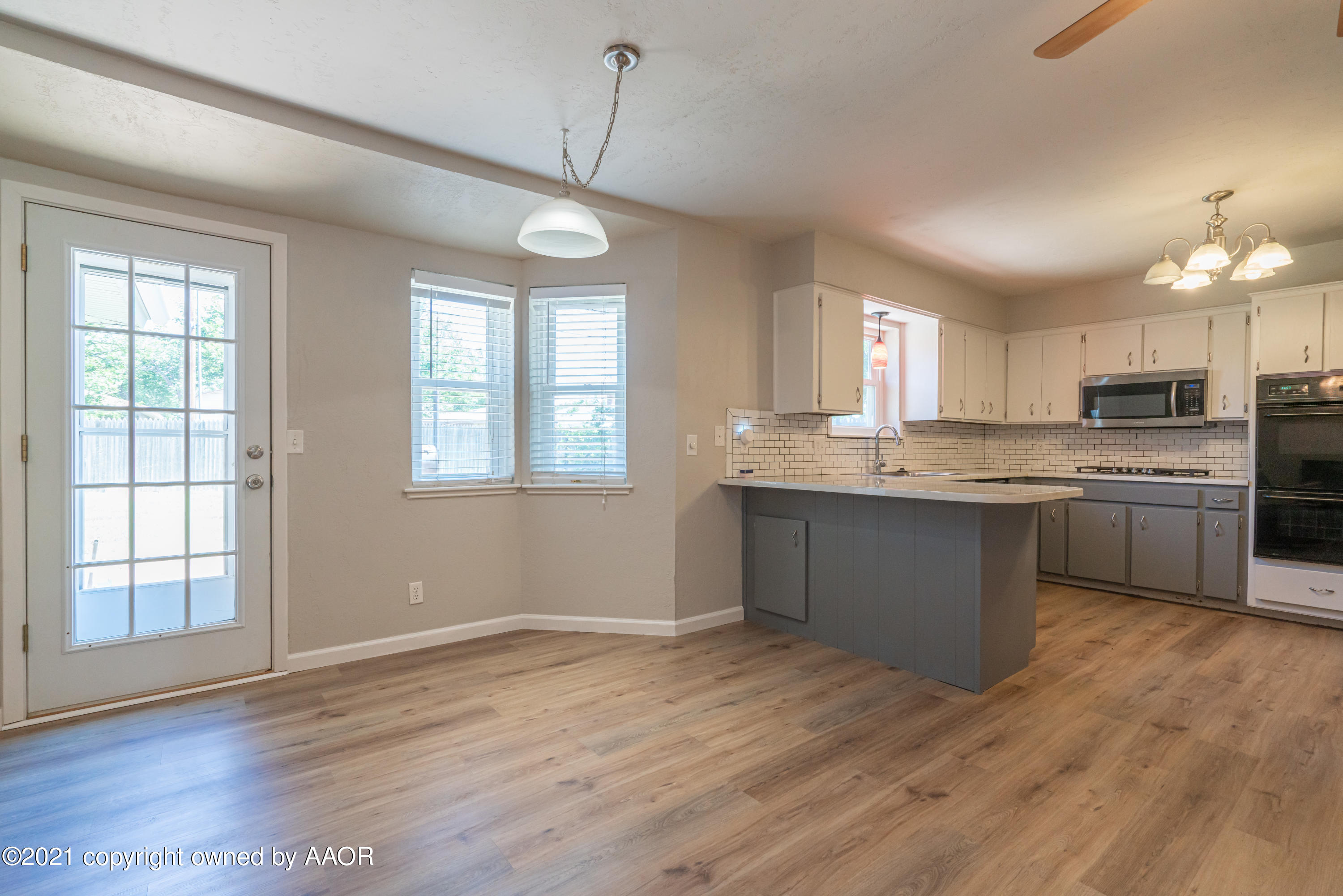 5308 Hillside Road Amarillo, TX 79109 - Photo 6 of 23 a kitchen with stainless steel appliances granite countertop a stove a sink dishwasher a refrigerator and white cabinets with wooden floor