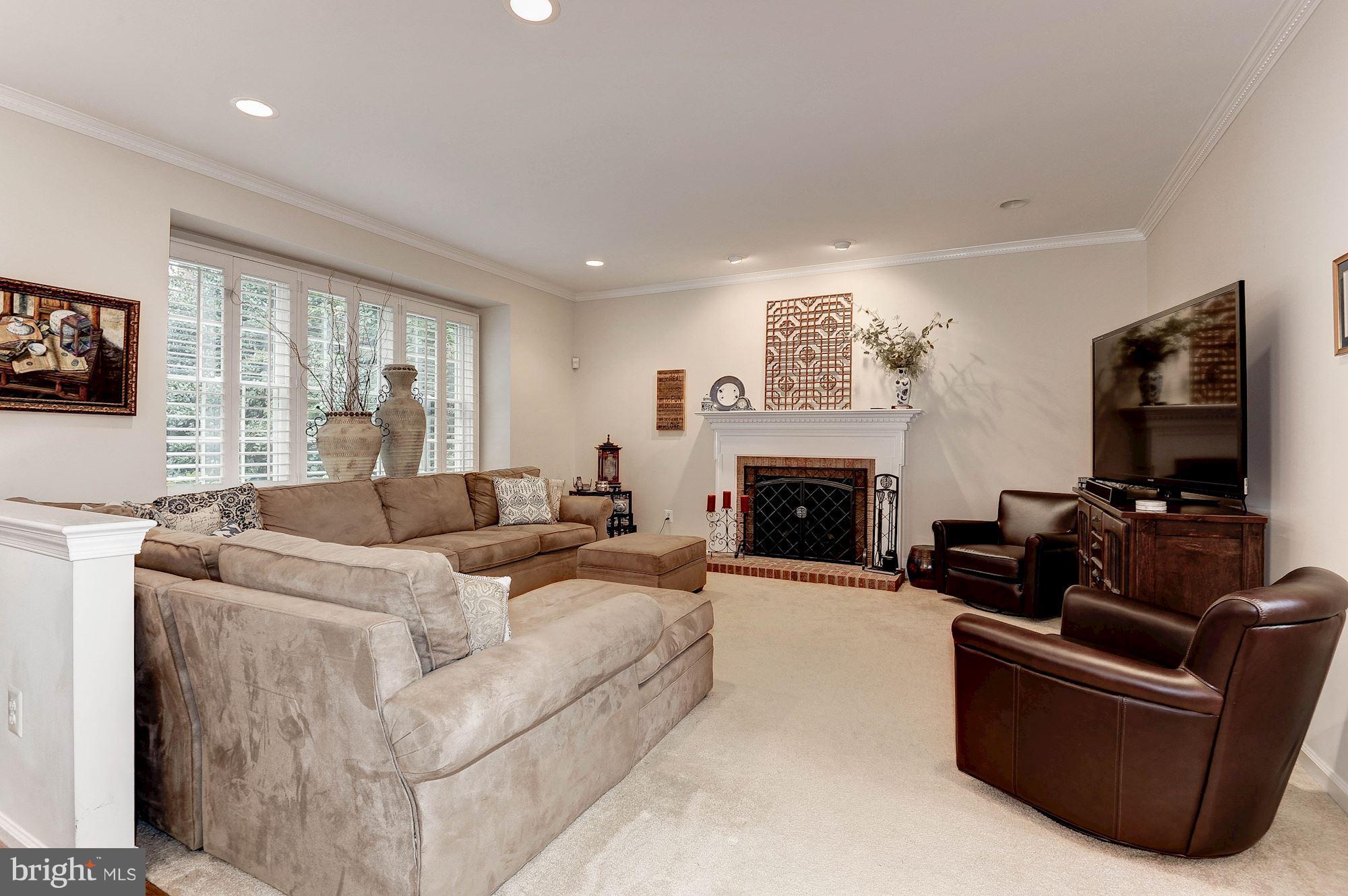 1328 Murray Downs Way Reston, VA 20194 - Photo 5 of 30 a living room with furniture a flat screen tv and a fireplace