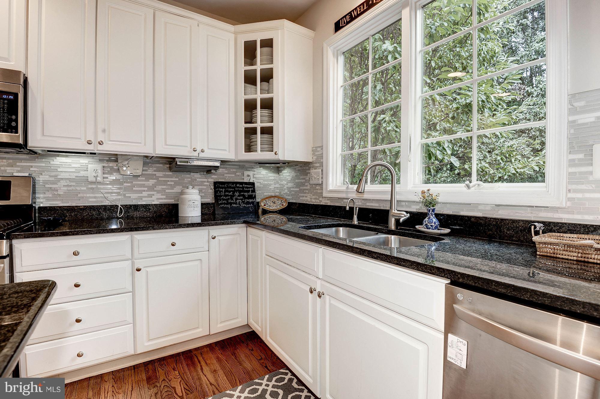 1328 Murray Downs Way Reston, VA 20194 - Photo 9 of 30 a kitchen with granite countertop white cabinets and a window