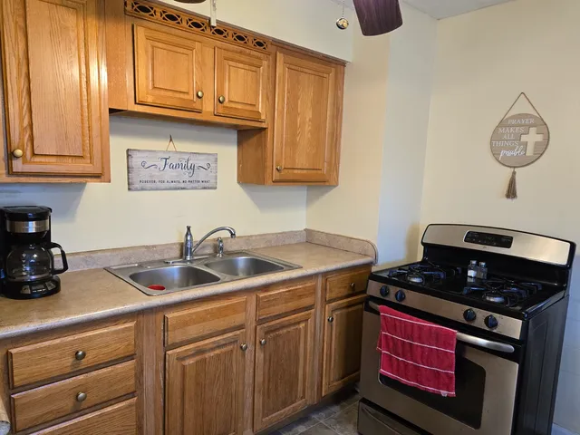 a kitchen with stainless steel appliances granite countertop a sink a stove and cabinets