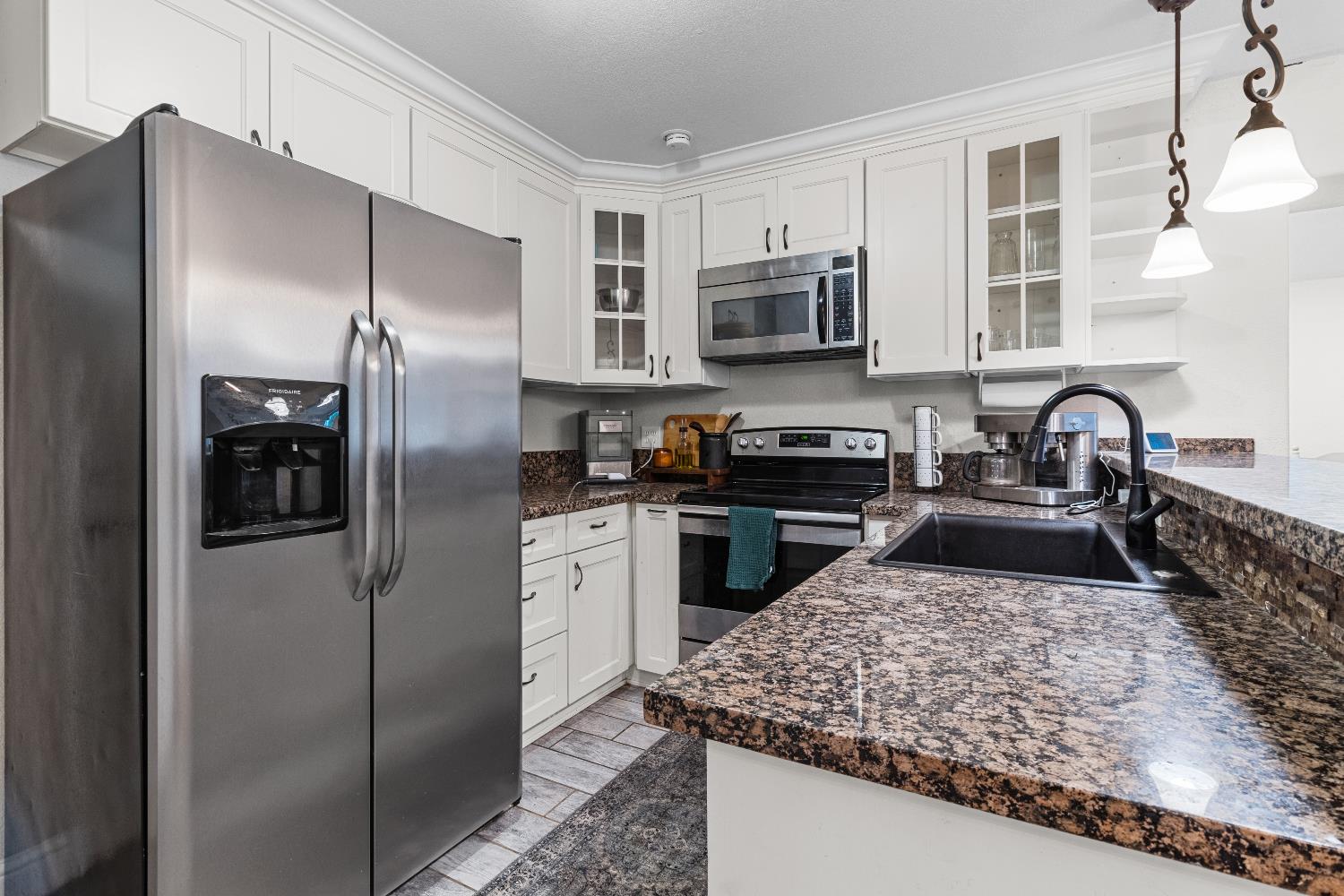 3319 U Street Antelope, CA 95843 - Photo 2 of 14 a kitchen with stainless steel appliances granite countertop a refrigerator a stove and a sink with granite countertops
