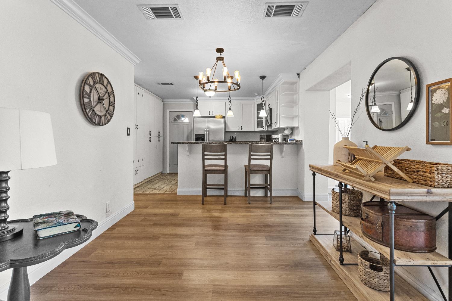 3319 U Street Antelope, CA 95843 - Photo 3 of 14 a kitchen with stainless steel appliances granite countertop a stove top oven a clock and a view of wooden floor