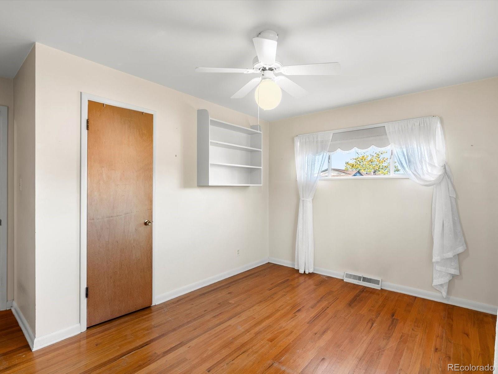9815 West 37th Avenue Wheat Ridge, CO 80033 - Photo 20 of 50 a view of empty room with wooden floor and fan