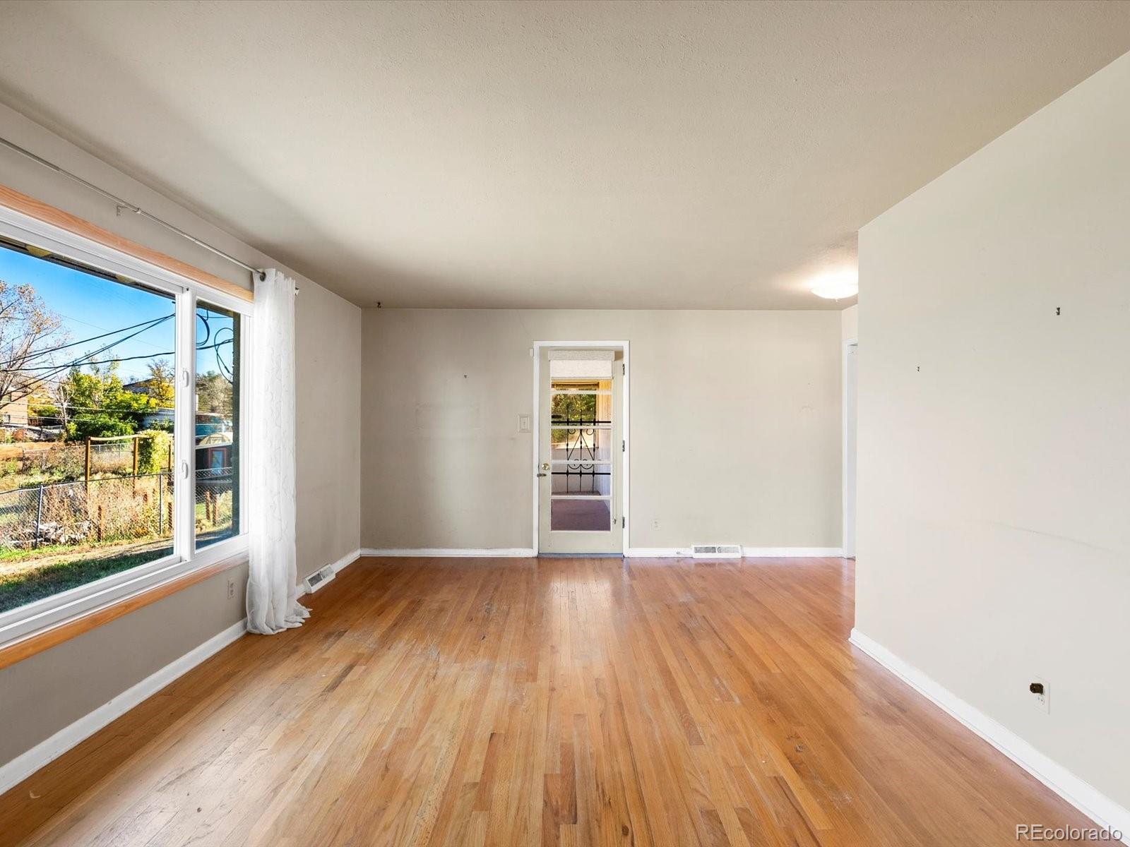 9815 West 37th Avenue Wheat Ridge, CO 80033 - Photo 4 of 50 an empty room with wooden floor and windows