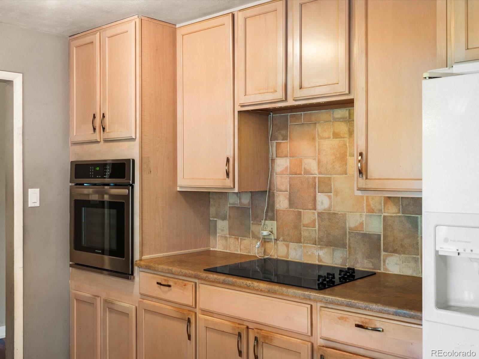 9815 West 37th Avenue Wheat Ridge, CO 80033 - Photo 8 of 50 a kitchen with granite countertop a sink and cabinets