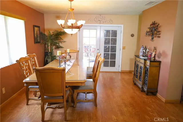 a dining room with furniture a chandelier and wooden floor
