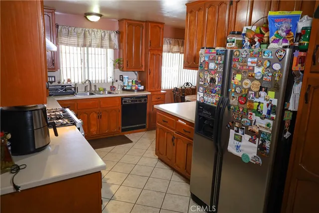a kitchen with stainless steel appliances granite countertop a sink a counter space and a window