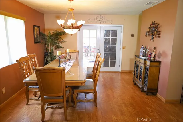 a dining room with furniture a chandelier and wooden floor