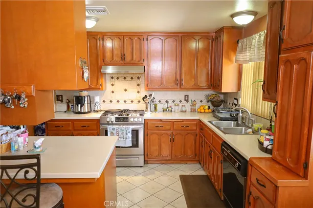 a kitchen with stainless steel appliances granite countertop a stove a sink and a refrigerator